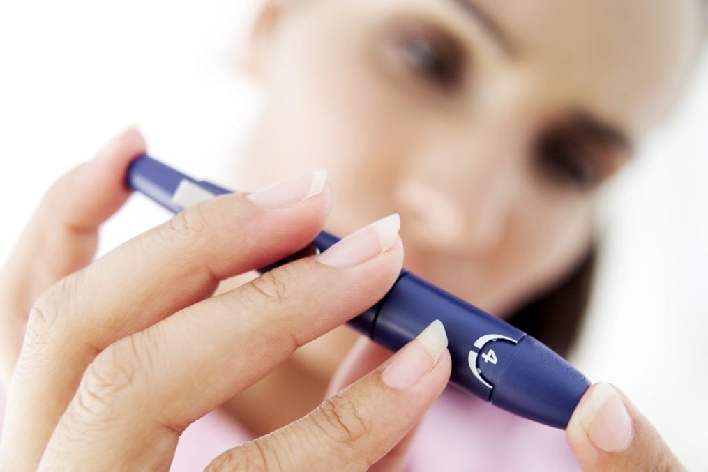 close-up of a woman removing blood from her finger for a blood test