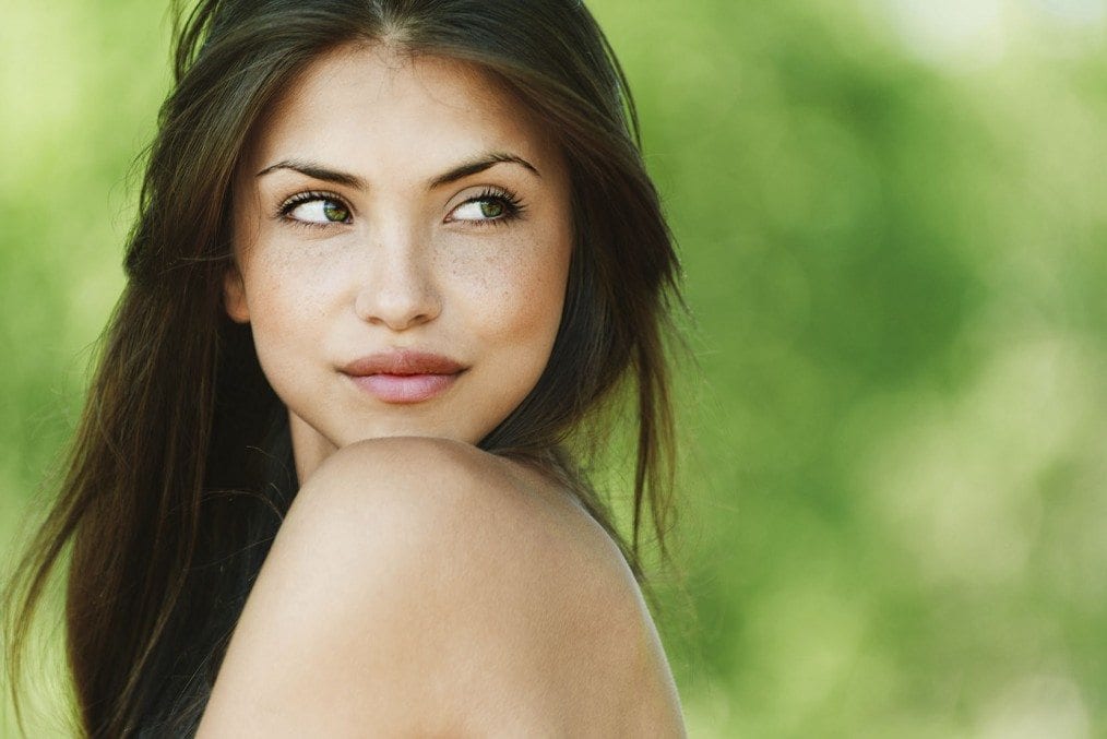 girl looking over her bare shoulder