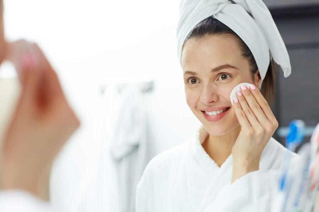 Woman wiping her face with cotton