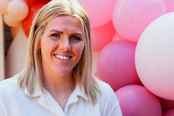 England and Chelsea footballer Millie Bright standing in front of a pile of balloons